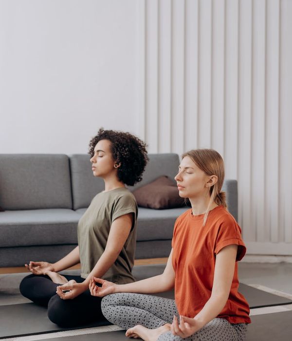 Woman in a serene yoga pose in a bright, minimalist room.